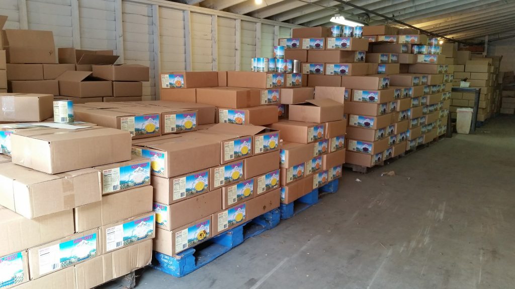Stacks of fresh produce, bulk grains, and culinary essentials in a warehouse setting, showcasing a comprehensive range of food items and restaurant supplies ready for distribution.